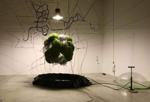 Tomás Saraceno, 32SW Stay Green/Flying Garden/Air-Port-City, 2007. Pillows with pressurized air, webbing, covered with black felt, grass, solar flexible panels, electrical cables, battery, solar pump, water supply system. 192-15/16 in. diameter. Courtesy the artist and Tanya Bonakdar Gallery, New York