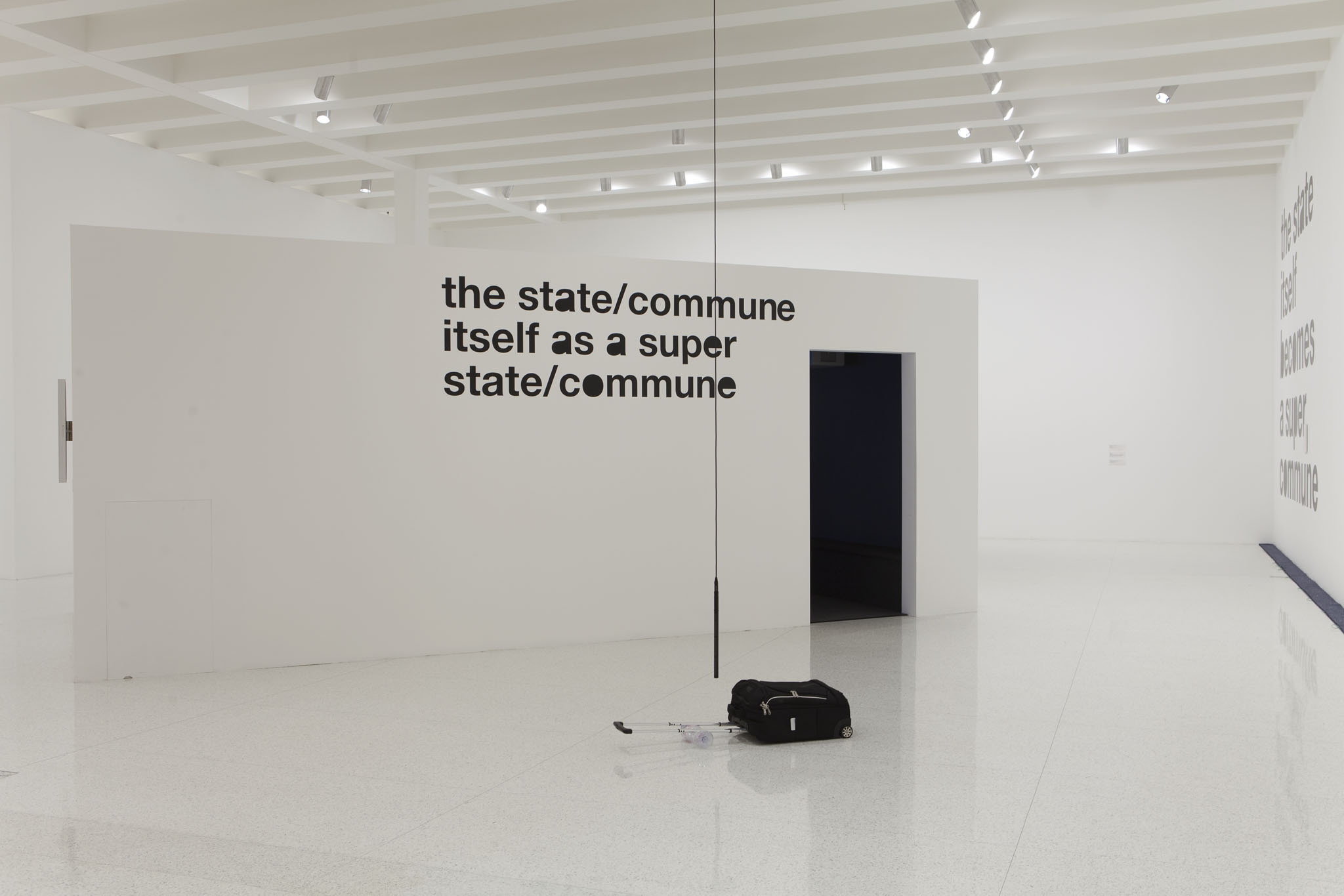 Installation view. Liam Gillick, The state/commune itself becomes a super state/commune. Natasha Sadr De Paso in foreground. Photography by Gene Pithman